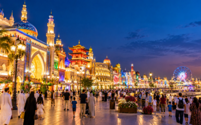 Global Village Dubai at night with illuminated cultural pavilions and visitors